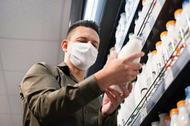 Foto persona comprando con mascarilla