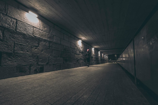 Persona corriendo por el túnel de noche
