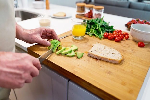 Persona cortando un aguacate en la cocina.