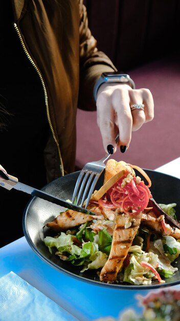 Foto una persona está cortando comida con un cuchillo y un tenedor