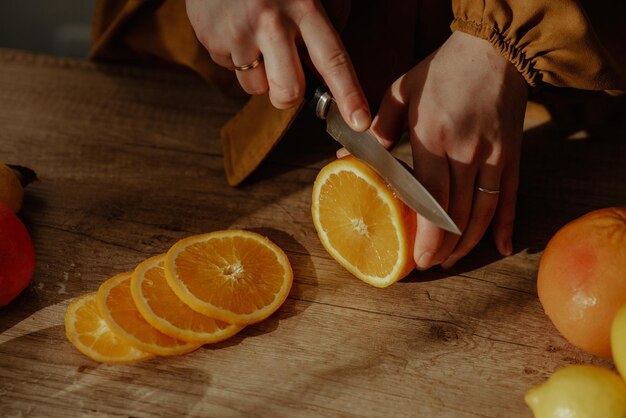 Foto una persona cortando naranjas en una tabla de cortar