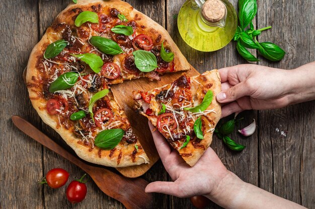 Una persona cortando una pizza a la que le han quitado un trozo.