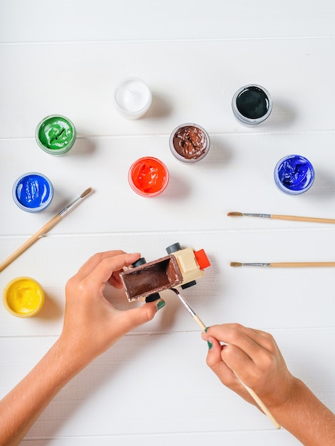 Foto la persona cubre el costado del automóvil de madera con pintura marrón.