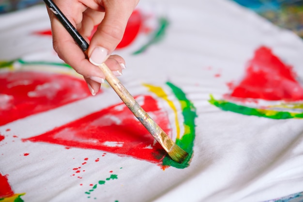 Persona dibuja rodajas de sandía en una camiseta blanca