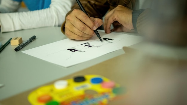 Persona dibujando a mano con pluma, lápiz y tinta, perspectivas arquitectónicas en color.