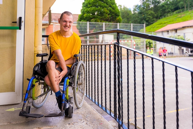 Foto una persona discapacitada vestida de amarillo en silla de ruedas en el patio de la escuela