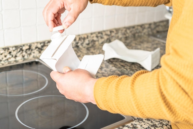 Persona doblando y reciclando empaques de larga duración listos para ser reciclados como deben ser