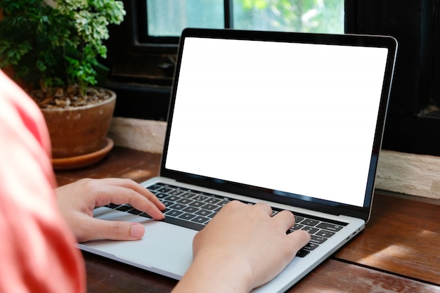 Foto persona escribiendo en computadora con pantalla en blanco