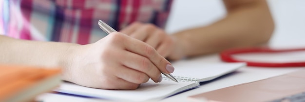 Persona escribiendo ideas en el diario tomando notas para el futuro día de planificación que el hombre usa para escribir plata p