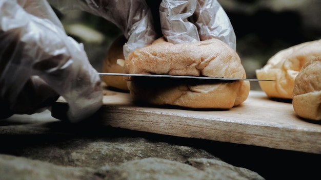 Una persona está cortando un sándwich con un cuchillo.