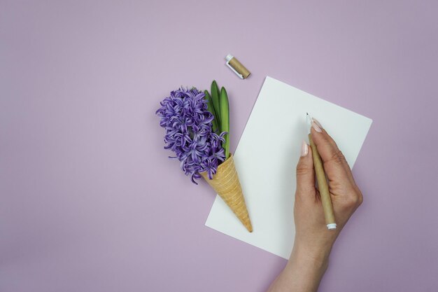 Una persona está escribiendo en un bloc de notas con un lápiz y un lápiz.