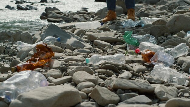 Una persona está de pie sobre las rocas con una botella de agua.