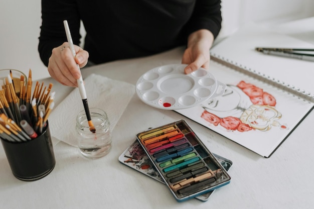 una persona está pintando una paleta de pintura en una mesa