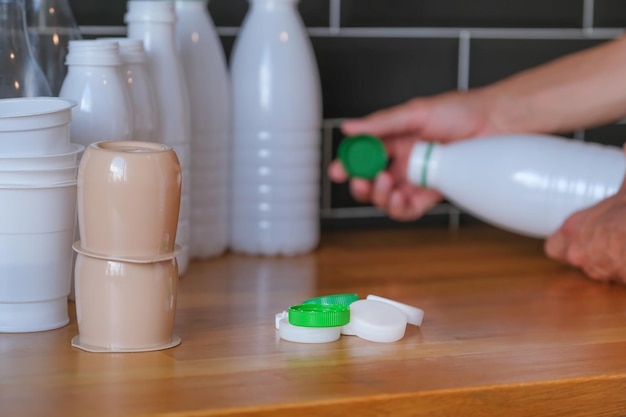 persona está separando residuos para reciclar, tapas de botellas de colores, residuos de alimentos plásticos en primer plano