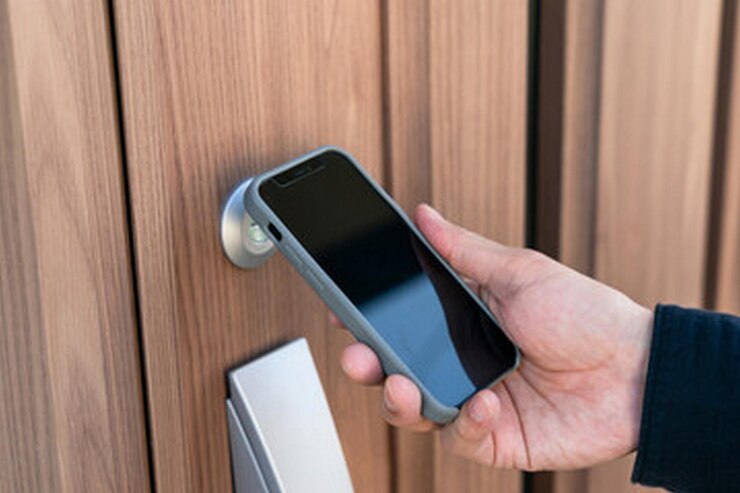 una persona está sosteniendo un teléfono con una llave en la mano