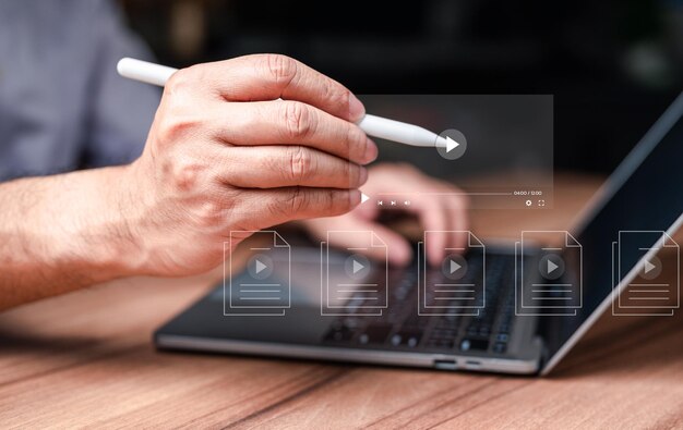 Una persona está usando una computadora portátil con un bolígrafo blanco en la mano