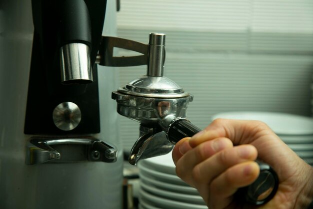 Una persona está usando una máquina de café con un reloj en la muñeca.