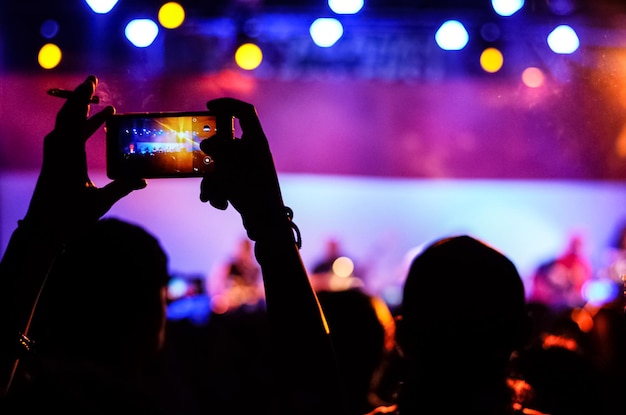 Persona fotografiando en un concierto de música