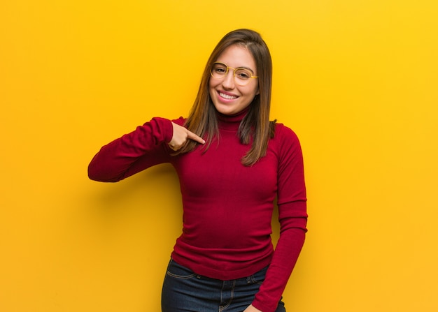 Persona intelectual joven que señala a mano a una camisa copyspace, orgullosa y confiada