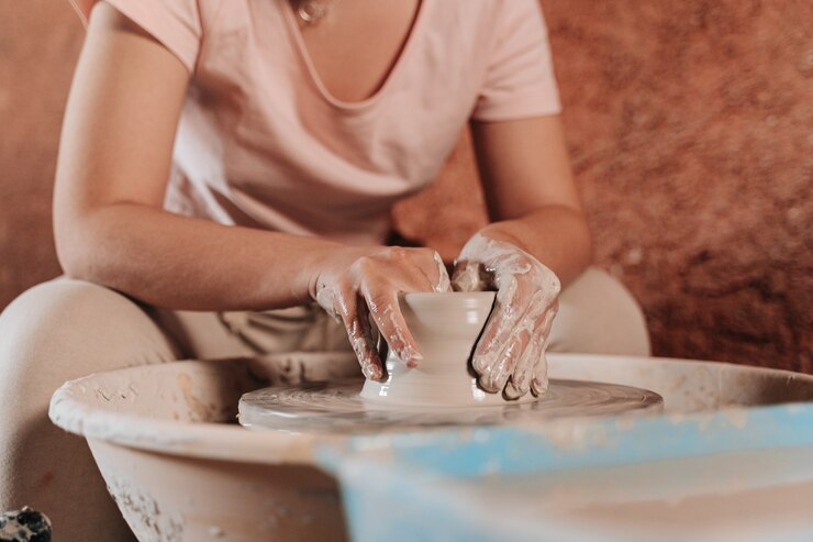 Foto persona irreconocible dando forma a un material llamado terracota