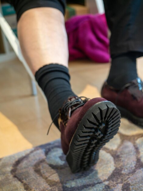 Persona irreconocible en la tienda probando zapatos nuevos