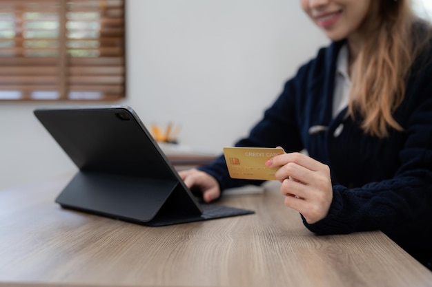 Persona joven que usa tarjeta de crédito y computadora portátil Concepto de comercio electrónico de compras en línea