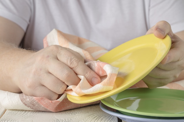 Persona lavando platos con productos de limpieza