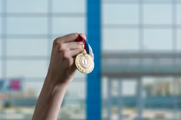 Una persona levantó la mano ganando el primer lugar, agarre la medalla de oro.