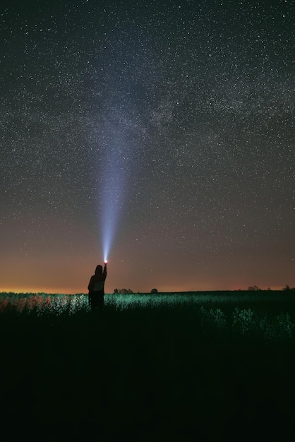 La persona con luz está mirando las estrellas por la noche.