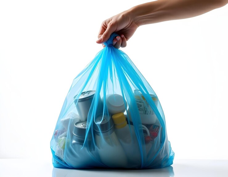 una persona con la mano sosteniendo una bolsa una bolsa de basura azul transparente aislada sobre un fondo blanco