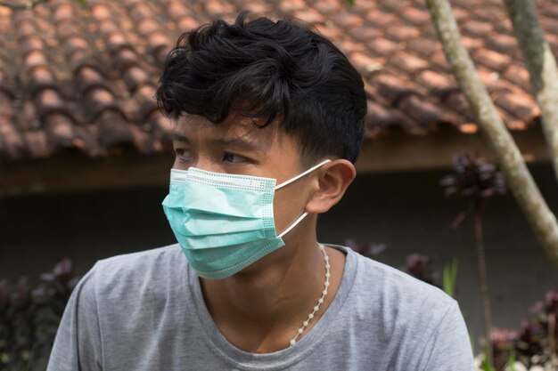 Foto persona con máscara facial joven con máscara de cara azul con una sonrisa en los ojos