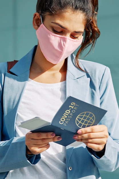 Foto persona con máscara con pasaporte de salud