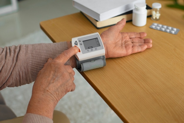 Persona mayor comprobando su presión arterial con tensiómetro