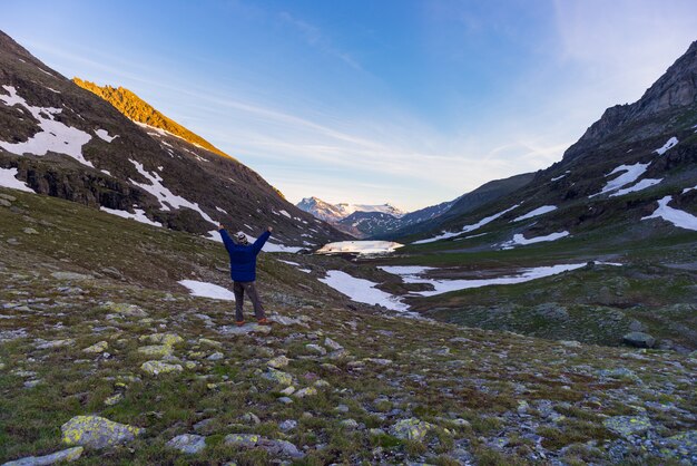 Una persona mirando colorido amanecer en lo alto de los Alpes.