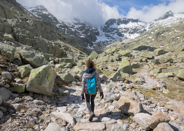 Persona con mochila caminando por la montaña en un día soleado. Circo de Gredos, parque nacional de Castilla y León, España.