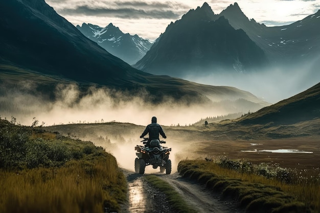 Foto persona montando atv en sendero de montaña con vista de picos cubiertos de niebla en la distancia