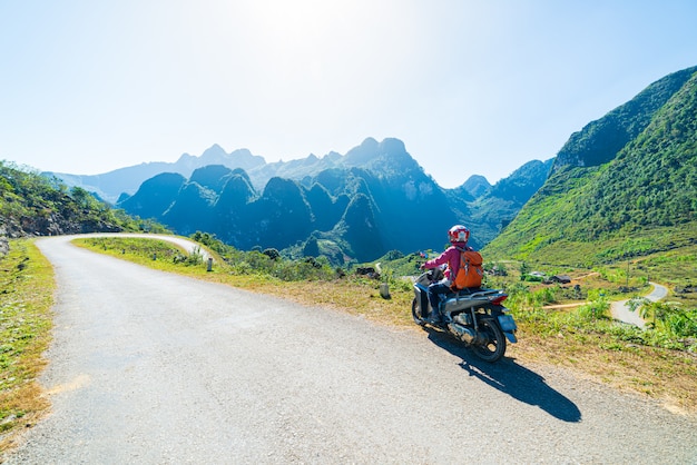 Una persona montando bicicleta en el circuito de motos de Ha Giang, ciclistas de destinos de viaje famosos, ciclistas fáciles. Ha Giang karst geopark paisaje de montaña en el norte de Vietnam. Camino sinuoso en un paisaje impresionante.