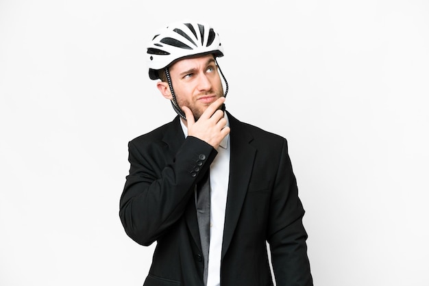 Persona de negocios con un casco de bicicleta sobre un fondo blanco aislado que tiene dudas