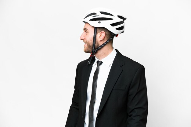 Persona de negocios con casco de bicicleta sobre fondo blanco aislado riendo en posición lateral