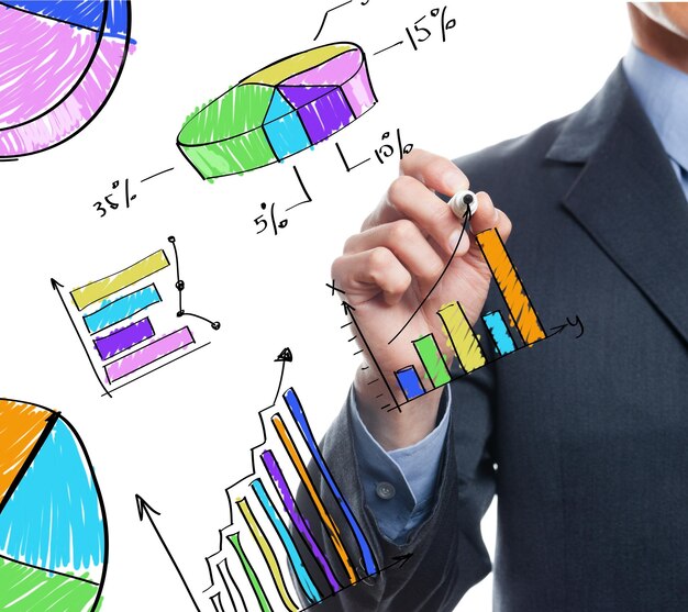 Persona de negocios dibujando gráficos y iconos coloridos en papel sencillo