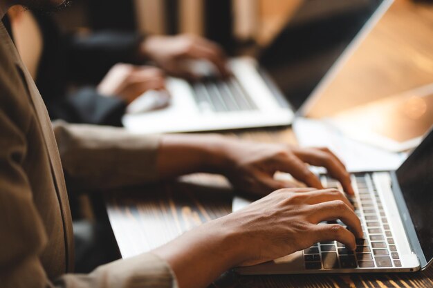 Persona de negocios profesional escribiendo en el escritorio de una computadora portátil en la oficina usando tecnología de teclado para trabajar en un trabajo de comunicación en el lugar de trabajo en línea