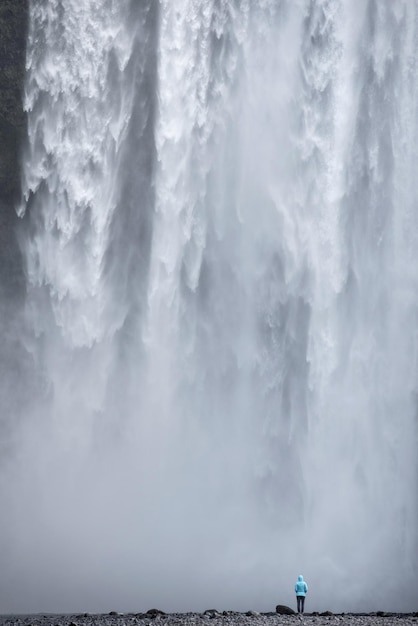 Foto persona de pie contra una cascada