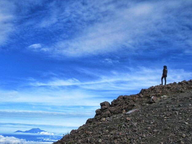 Persona de pie en la montaña contra el cielo