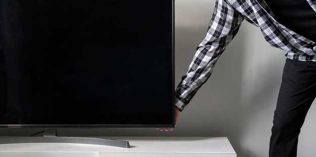 Una persona presiona el botón para encender el monitor