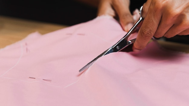 Foto persona de primer plano cortando un material de tela