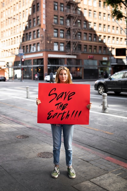 Foto persona protestando con pancarta en la ciudad por el día mundial del medio ambiente