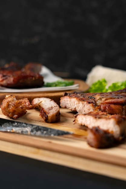 Persona que corta un filete de res cocido o asado con un cuchillo en una tabla de madera