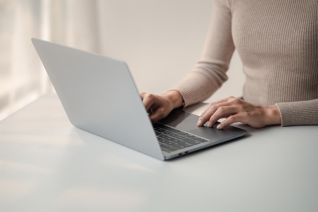 Persona que escribe en el teclado de una computadora portátil empresario que trabaja en una computadora portátil está escribiendo mensajes a sus colegas y haciendo una hoja de información financiera para resumir la reunión