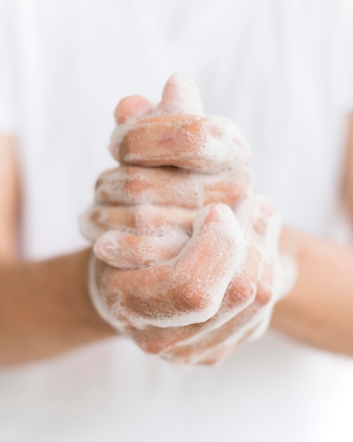 Foto persona que se lava las manos con jabón