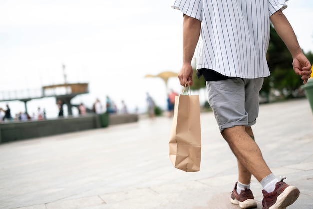 Una persona que lleva la bolsa de papel con alimentos frescos de la tienda.